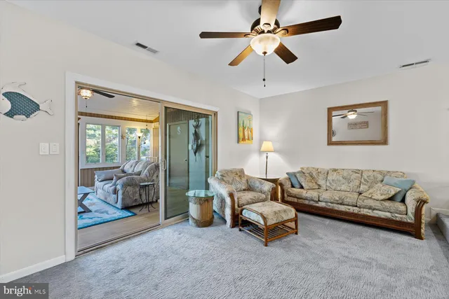 a living room with furniture and a ceiling fan