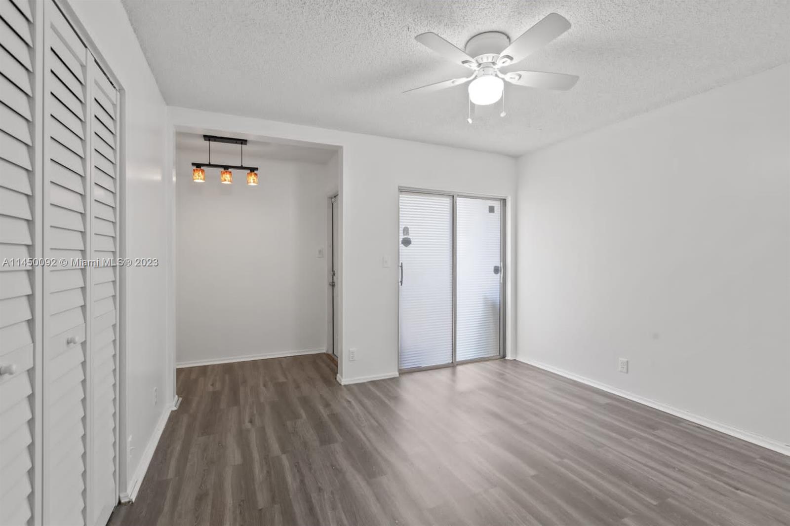 11671 Timbers Way Boca Raton, FL 33428 - Photo 14 of 25 a view of an empty room with chandelier fan and wooden floor