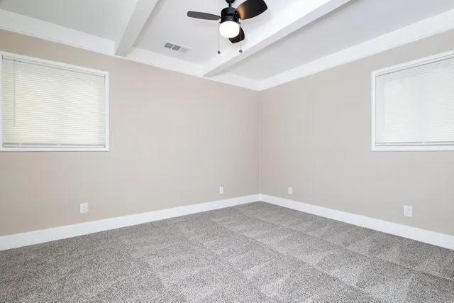 an empty room with a window and a ceiling fan