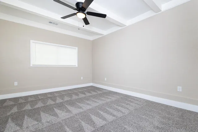 an empty room with a window and a fan