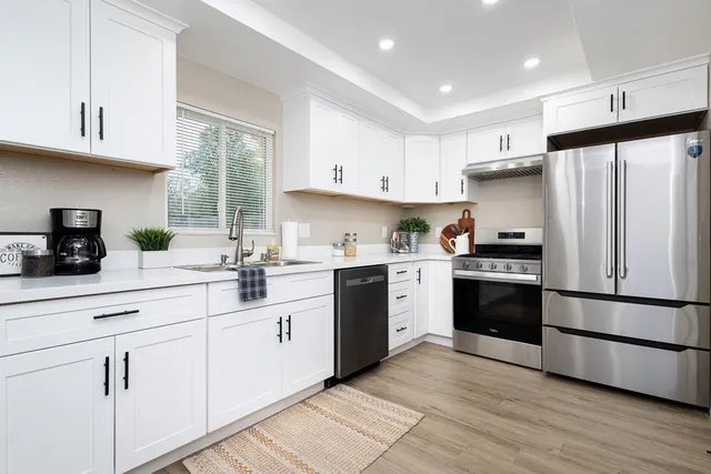 a kitchen with white cabinets and stainless steel appliances
