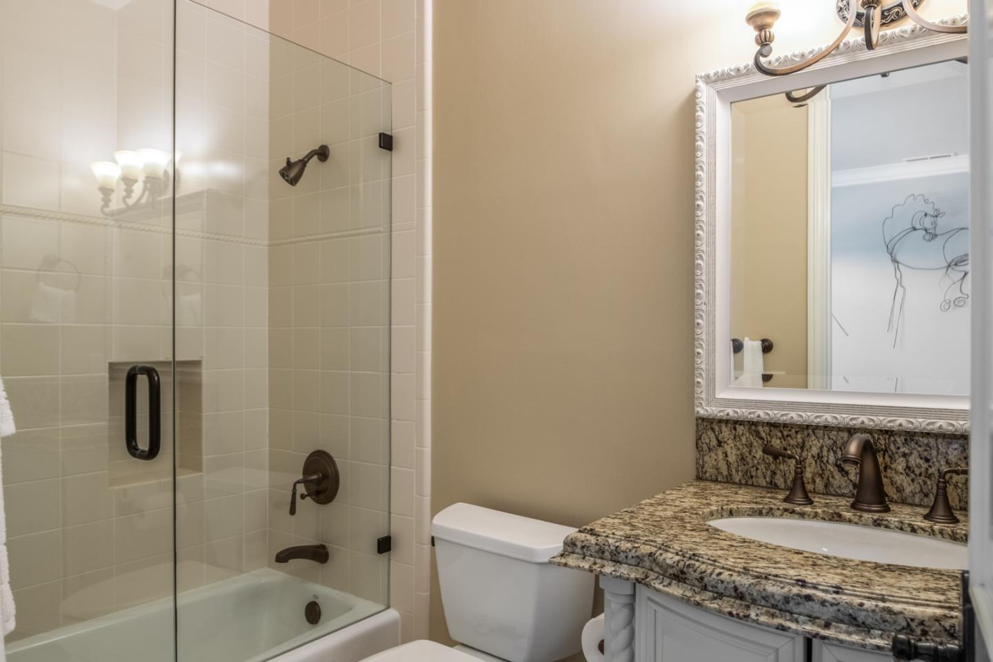 8630 River Meadows Road Carmel, CA 93923 - Photo 26 of 50 a bathroom with a granite countertop sink a mirror and a bathtub