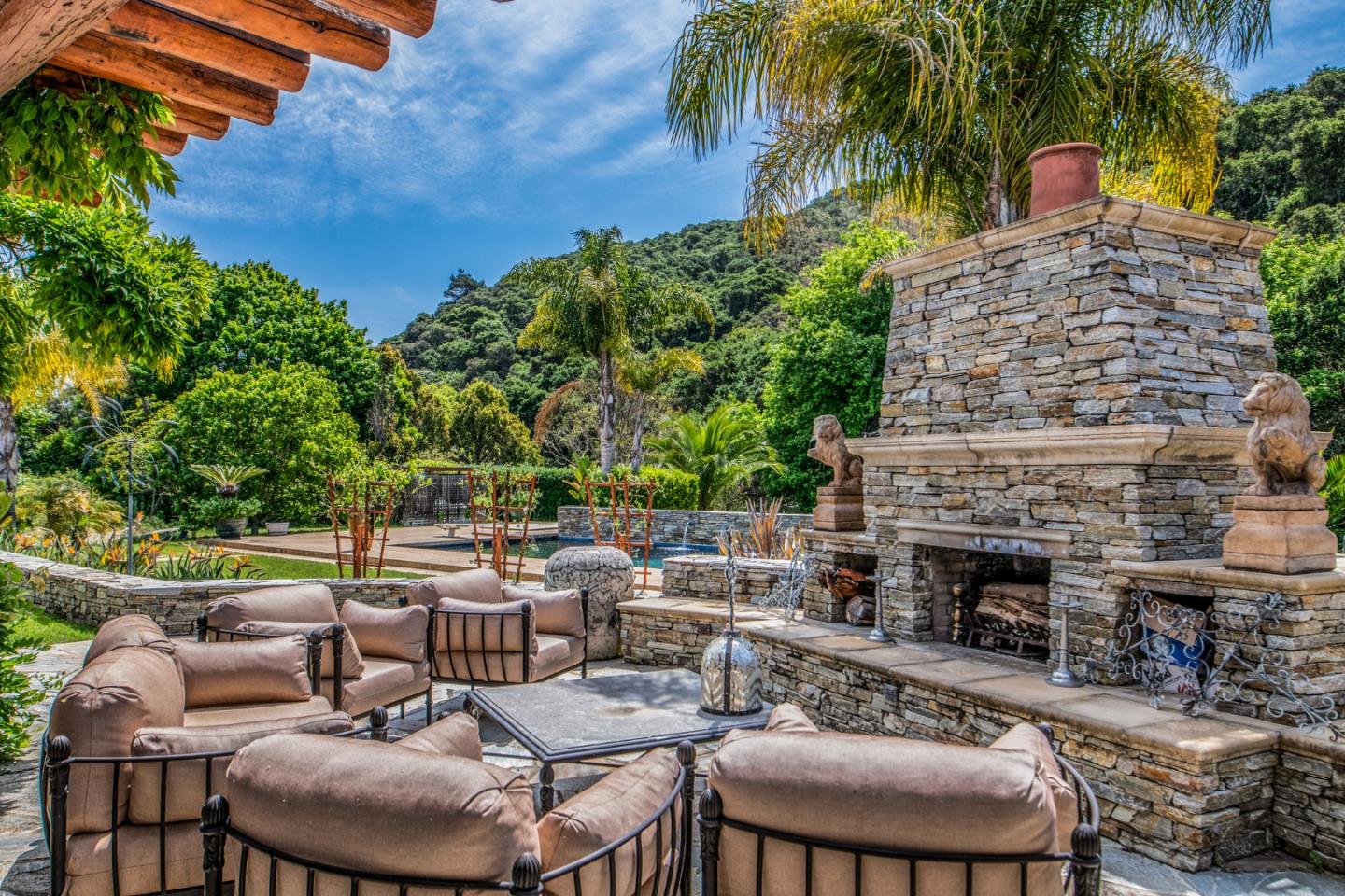 8630 River Meadows Road Carmel, CA 93923 - Photo 3 of 50 a view of a patio with table and chairs potted plants and a palm tree