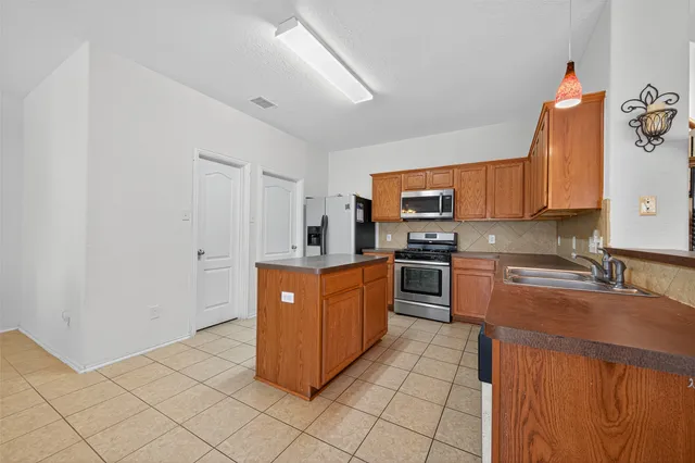 a kitchen with stainless steel appliances granite countertop a stove top oven a sink and dishwasher