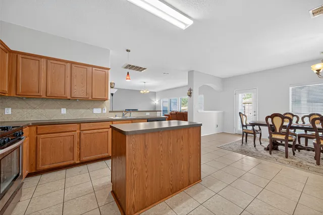 a kitchen with granite countertop cabinets and chairs