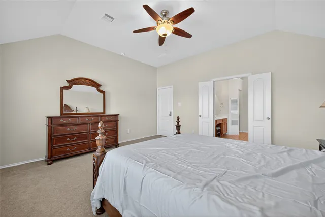 a bedroom with a bed and a dresser with a chandelier