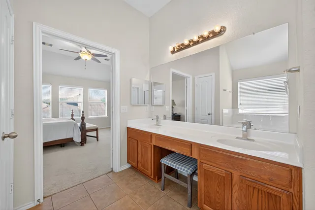 a en suite bathroom with a double vanity sink a mirror a bathtub and a shower