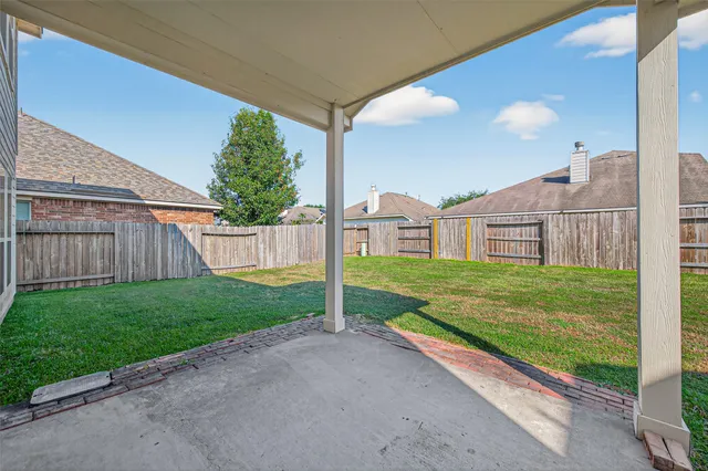 a view of a house with a yard and fence