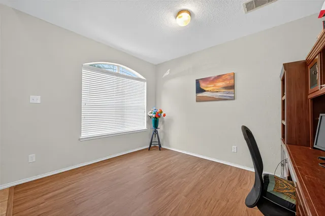 a view of a workspace with furniture and a window