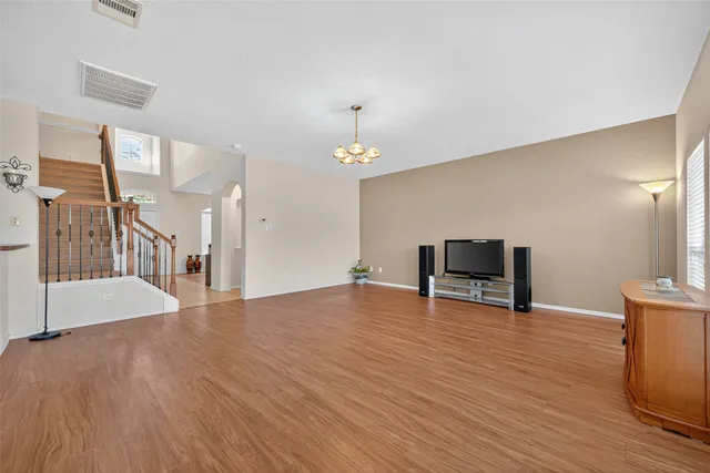 a view of an empty room with wooden floor and a cabinet