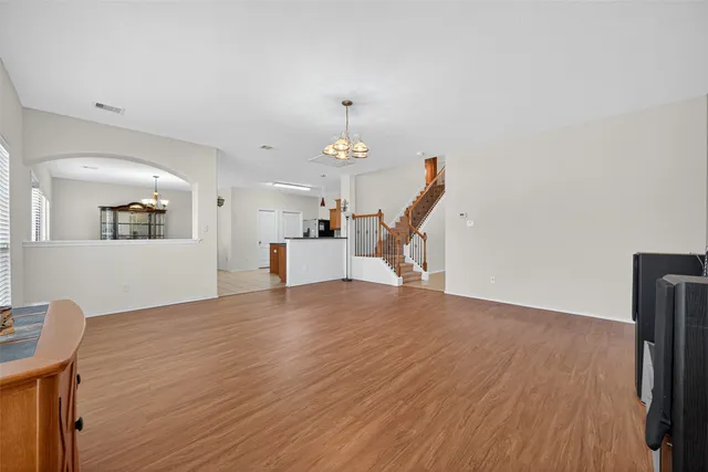 a view of empty room with wooden floor and ceiling fan