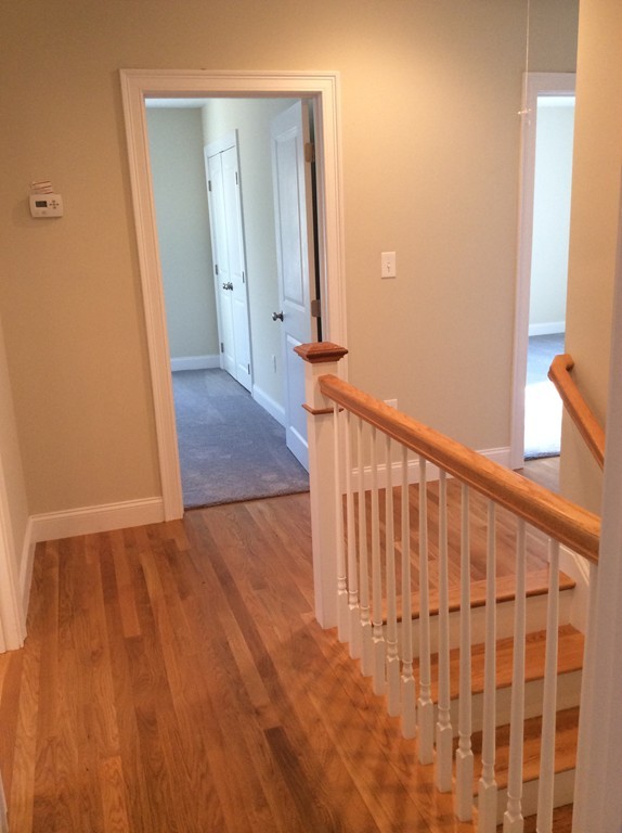 4 Maynard Road Sudbury, MA 01776 - Photo 11 of 22 a view of a hallway with wooden floor and a large window
