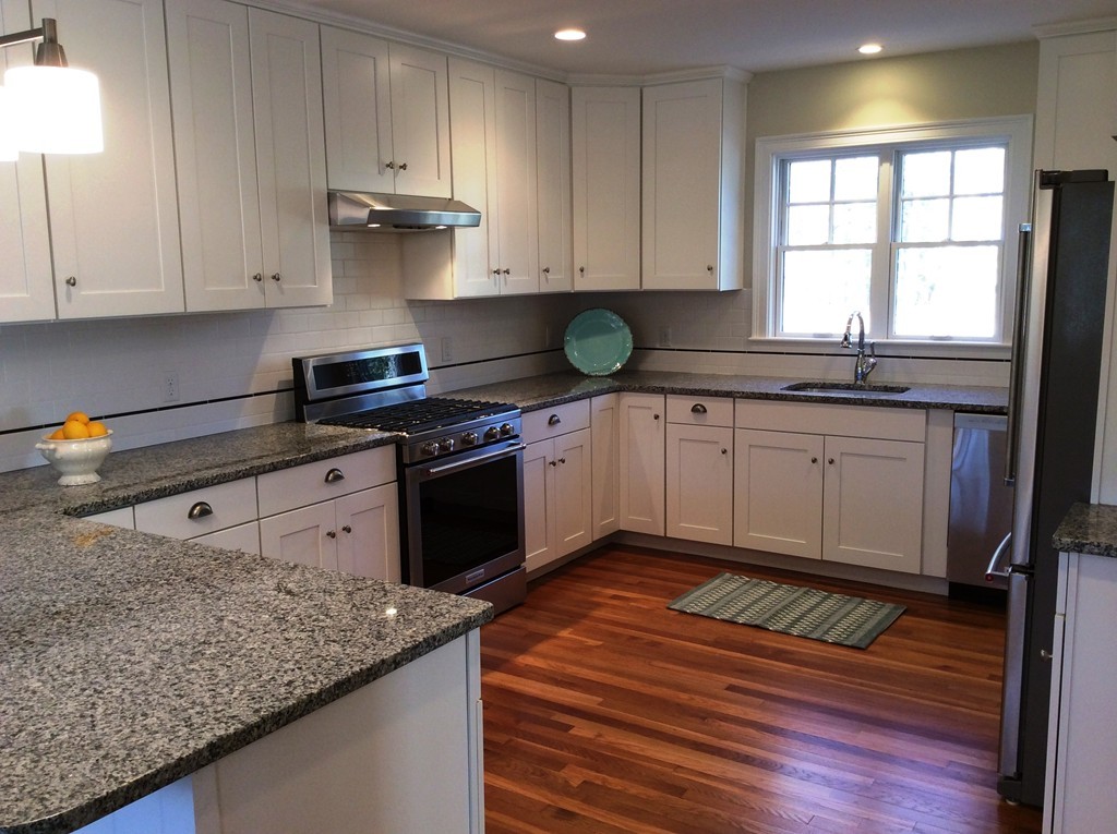 4 Maynard Road Sudbury, MA 01776 - Photo 8 of 22 a kitchen with stainless steel appliances granite countertop wooden cabinets and a stove top oven