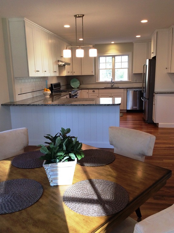 4 Maynard Road Sudbury, MA 01776 - Photo 9 of 22 a kitchen with stainless steel appliances granite countertop a refrigerator a sink a stove and a wooden floors