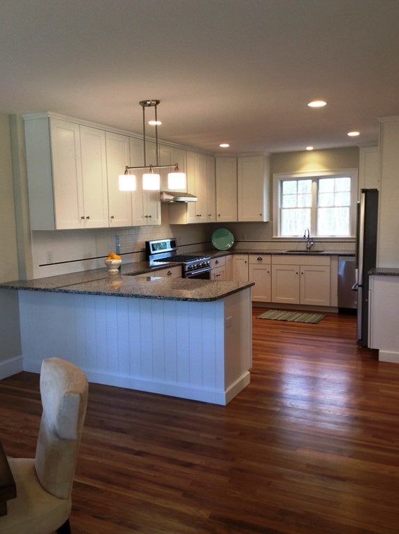 4 Maynard Road Sudbury, MA 01776 - Photo 10 of 22 a kitchen with granite countertop wooden floors cabinets a dining table and chairs
