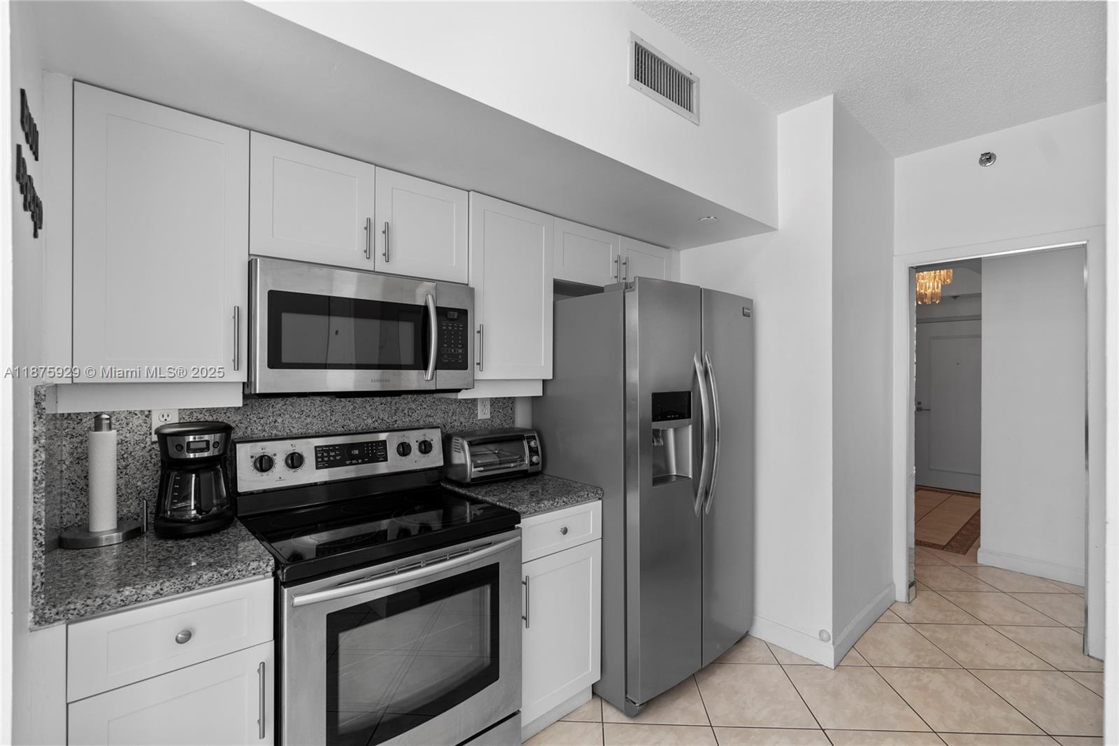 4201 Collins Avenue, Unit 701 Miami Beach, FL 33140 - Photo 18 of 61 a kitchen with stainless steel appliances granite countertop a refrigerator stove and sink