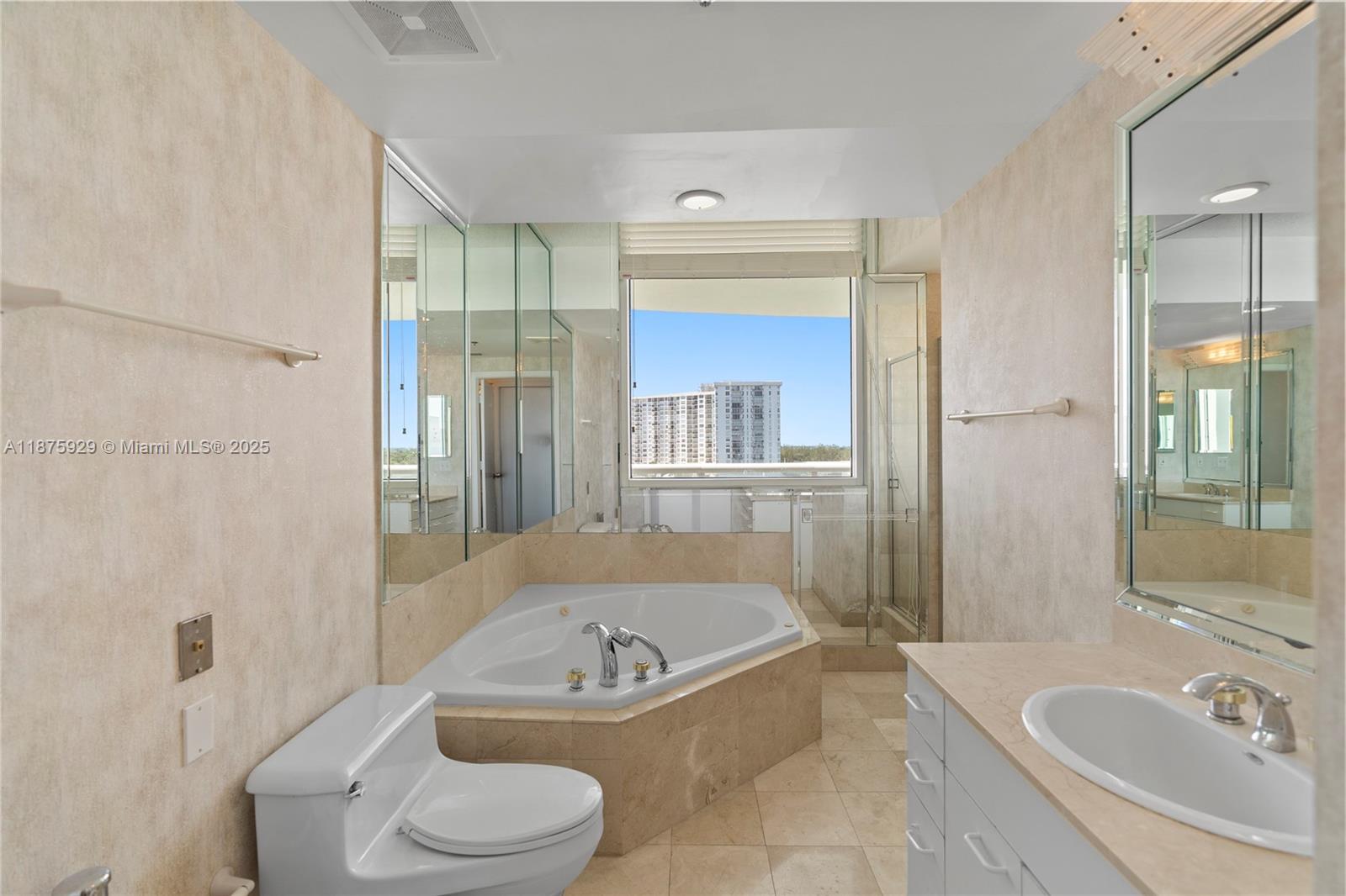 4201 Collins Avenue, Unit 701 Miami Beach, FL 33140 - Photo 25 of 61 a bathroom with a granite countertop bathtub sink vanity mirror and toilet