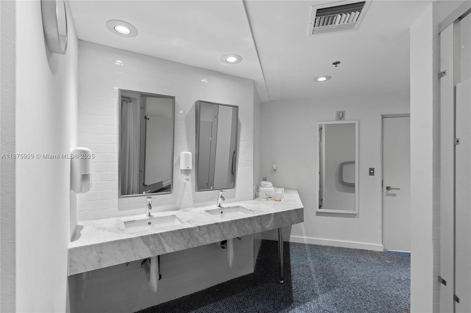 4201 Collins Avenue, Unit 701 Miami Beach, FL 33140 - Photo 57 of 61 a bathroom with double vanity sinks and a mirror