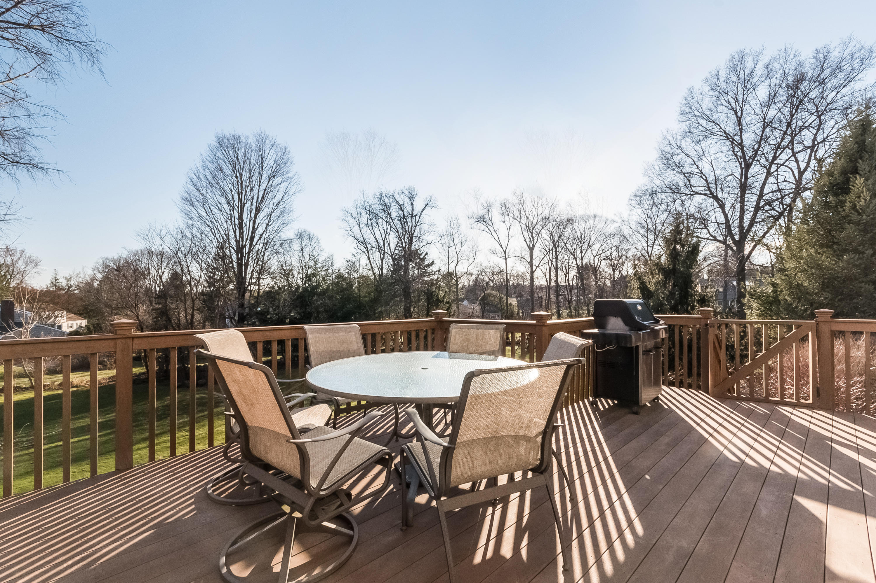 26 Stanton Road Darien, CT 06820 - Photo 35 of 40 a view of a roof deck with table and chairs couches with wooden floor and fence