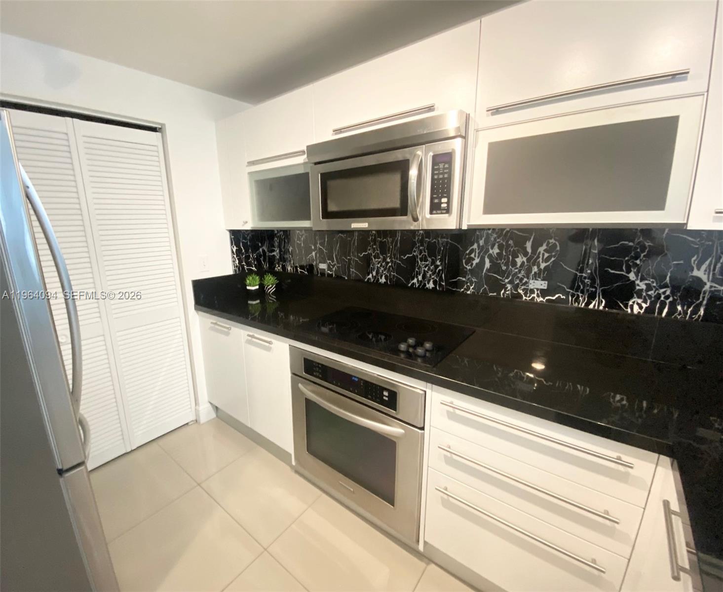 244 Biscayne Boulevard, Unit 1605 Miami, FL 33132 - Photo 13 of 48 a kitchen with a sink and a stove