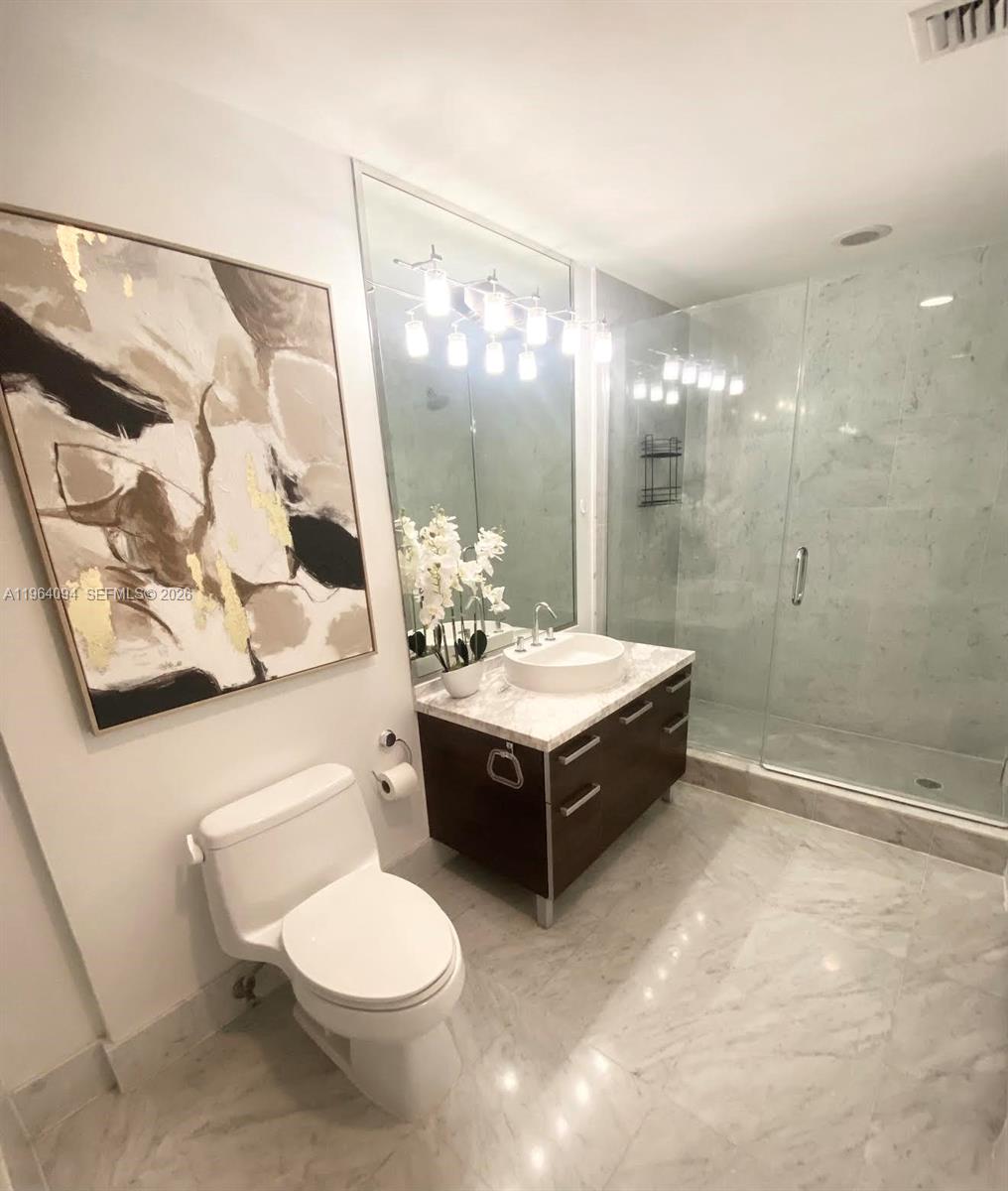 244 Biscayne Boulevard, Unit 1605 Miami, FL 33132 - Photo 28 of 48 a spacious bathroom with a double vanity sink toilet and shower
