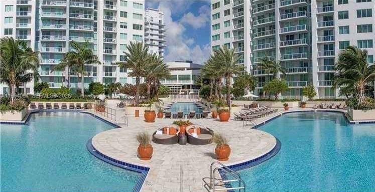 244 Biscayne Boulevard, Unit 1605 Miami, FL 33132 - Photo 37 of 48 a swimming pool with outdoor seating and water view