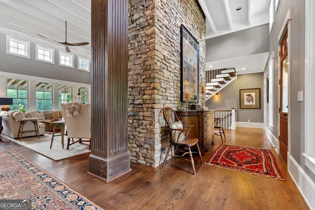 a kitchen with stainless steel appliances granite countertop a stove a sink dishwasher a refrigerator and white cabinets with wooden floor