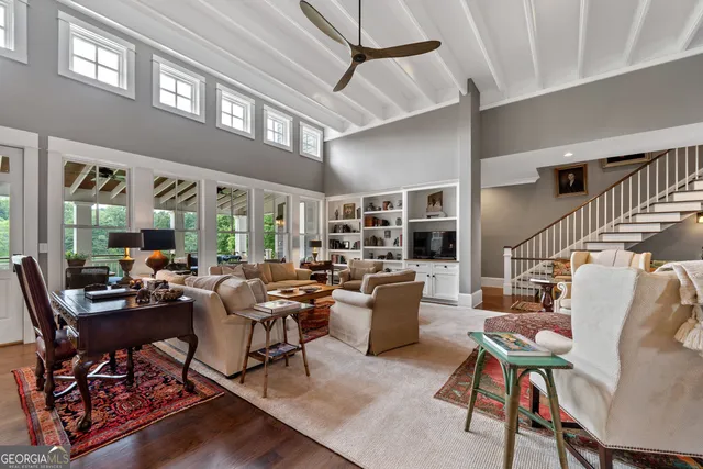 a kitchen with stainless steel appliances granite countertop a refrigerator a sink dishwasher a oven and a dining table with wooden floor