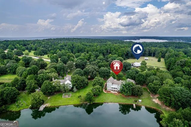 an aerial view of a house with a yard and lake view