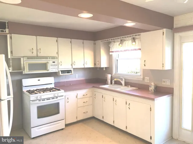 a kitchen with a stove a sink and a window