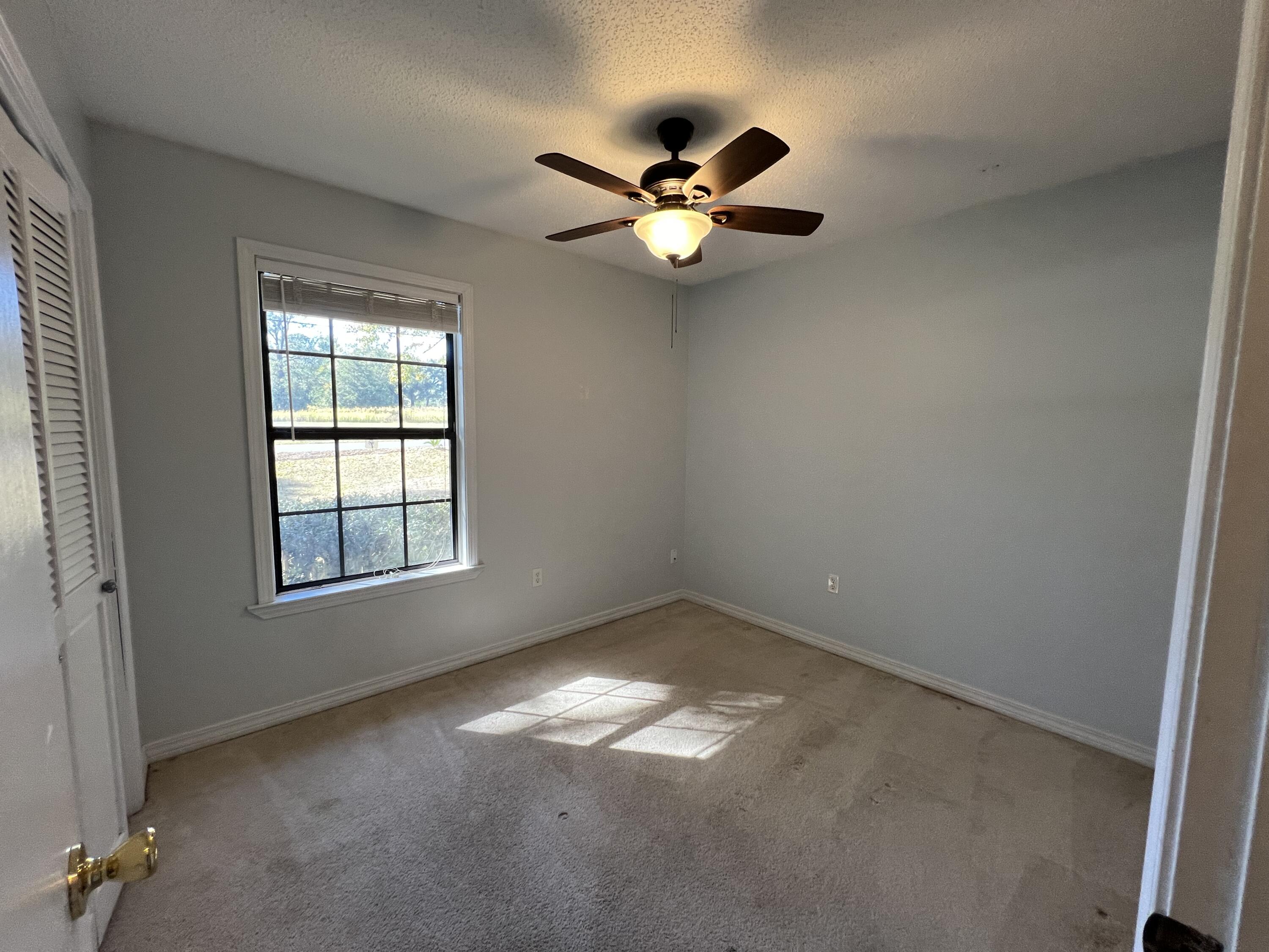 6028 Old Bethel Road Crestview, FL 32536 - Photo 6 of 16 an empty room with windows and fan