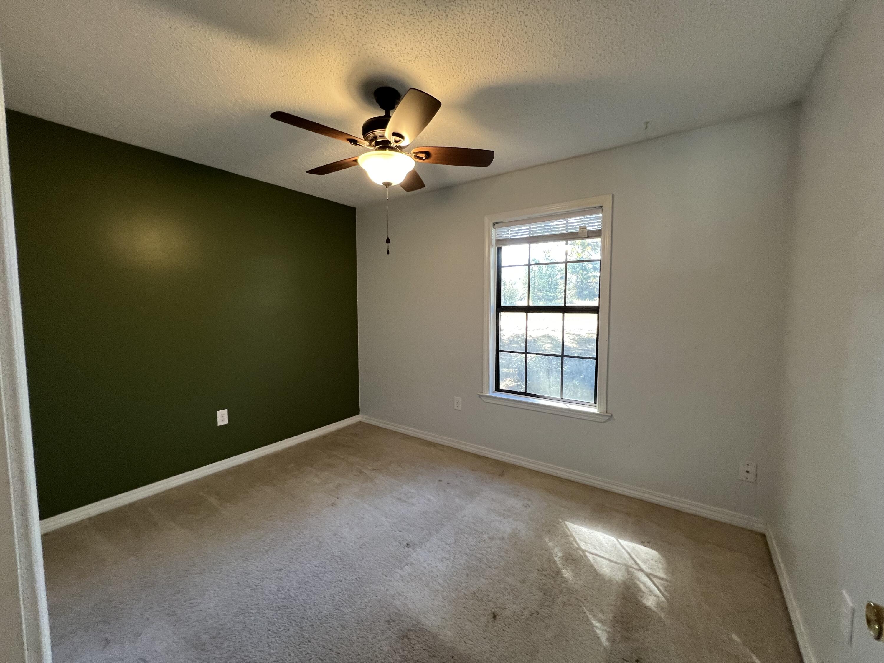 6028 Old Bethel Road Crestview, FL 32536 - Photo 7 of 16 an empty room with windows and fan