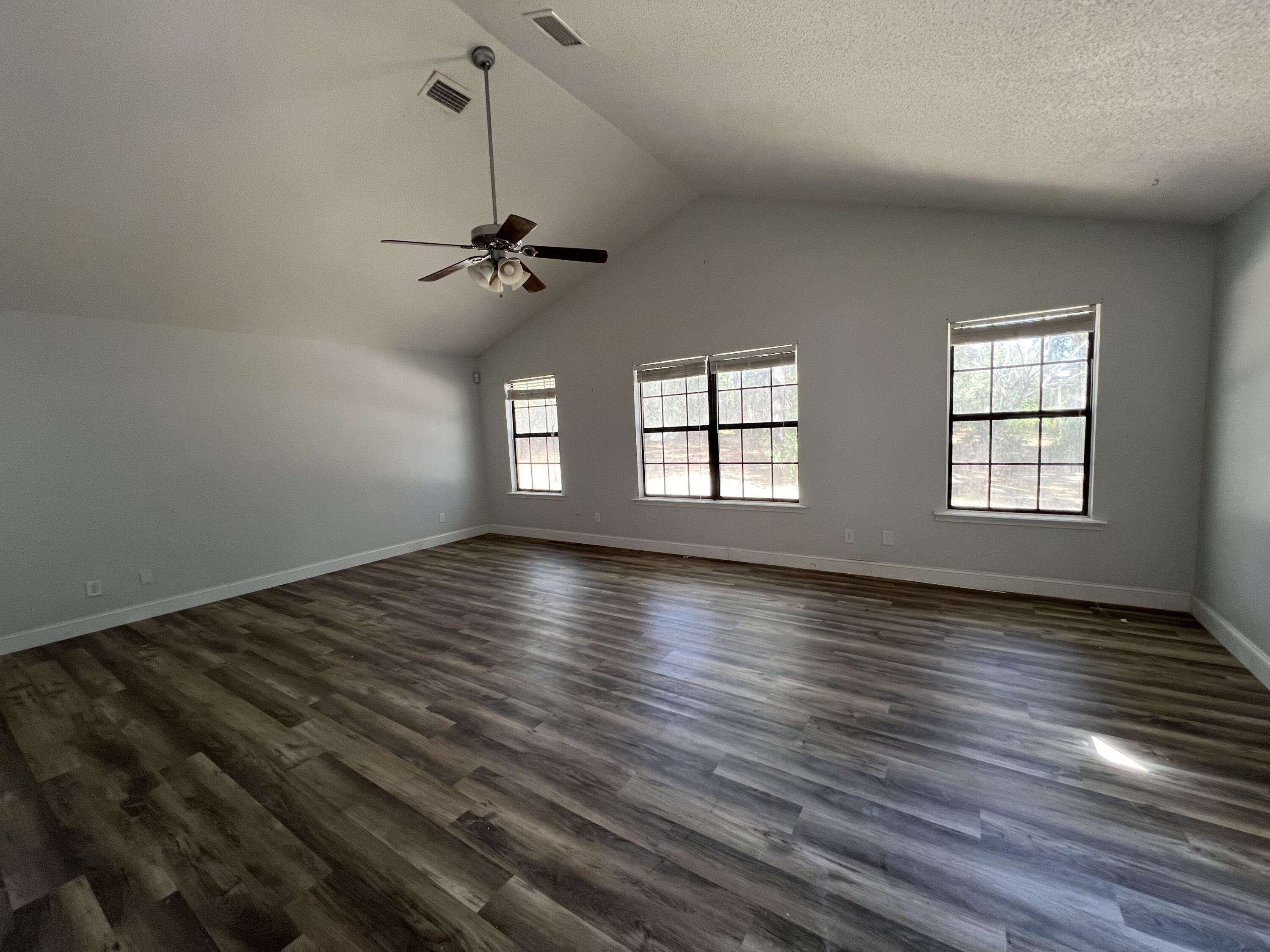 6028 Old Bethel Road Crestview, FL 32536 - Photo 9 of 16 a view of empty room with wooden floor and fan