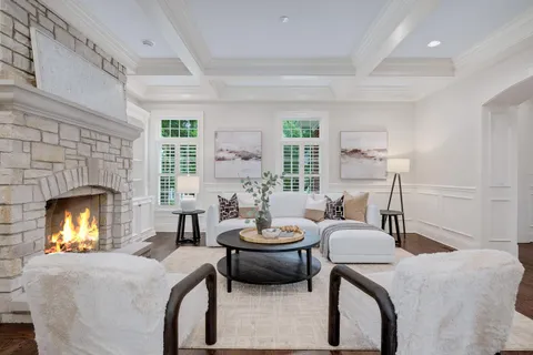 a bedroom with a bed large window and a chandelier