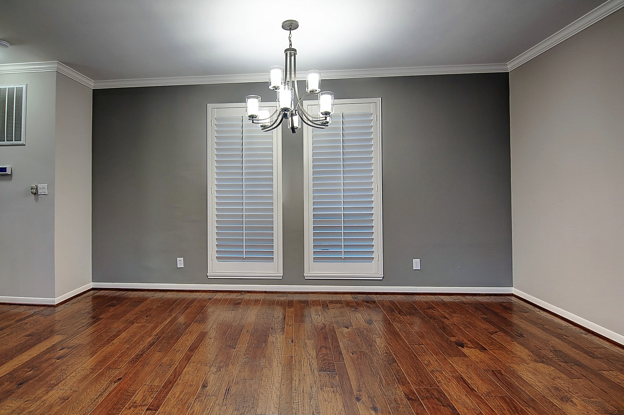1408 West Webster Street Houston, TX 77019 - Photo 11 of 46 an empty room with wooden floor chandelier and windows