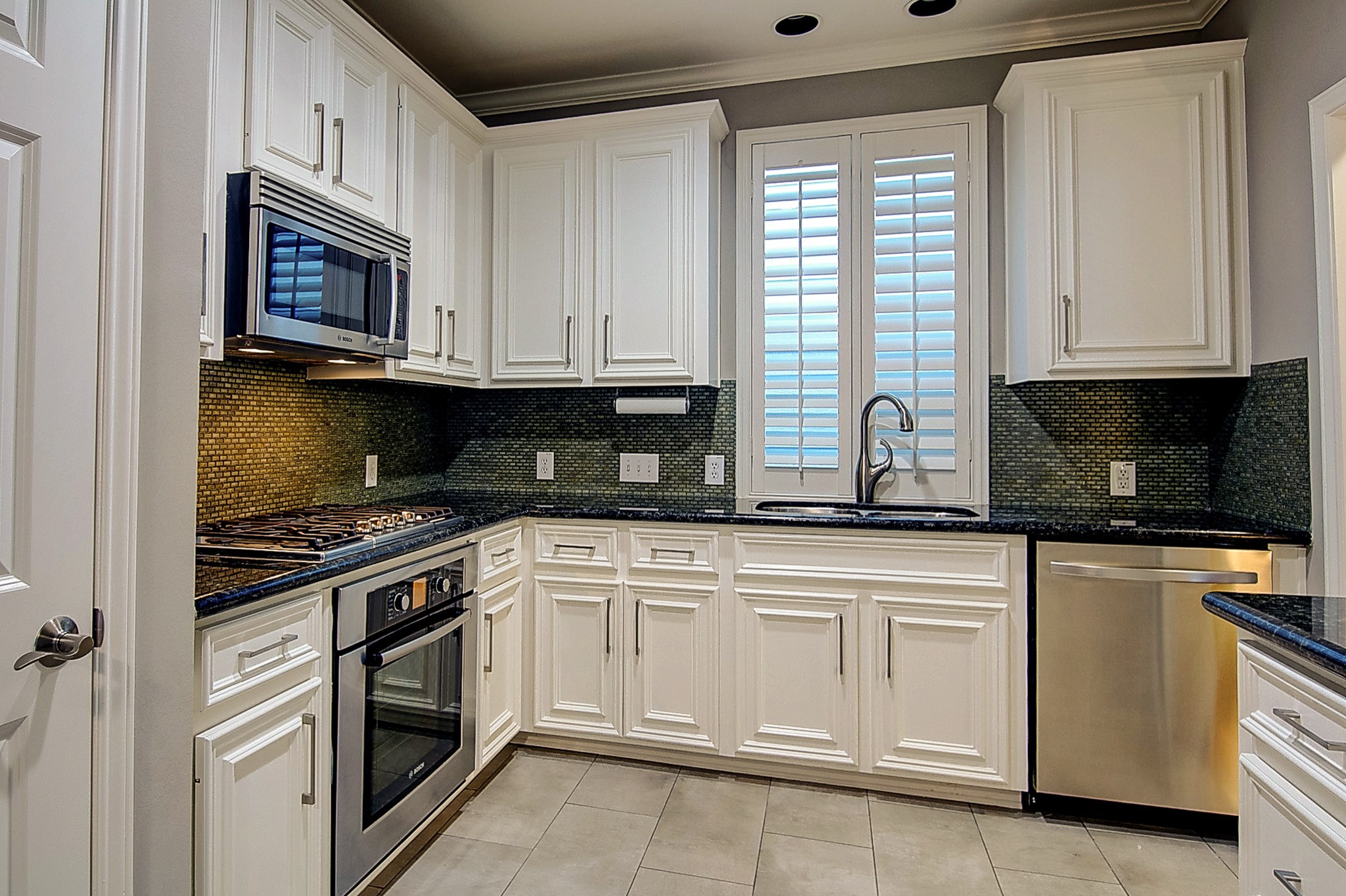 1408 West Webster Street Houston, TX 77019 - Photo 16 of 46 a kitchen with white cabinets stainless steel appliances and sink