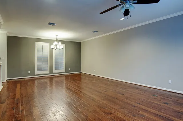 an empty room with a empty space and chandelier fan