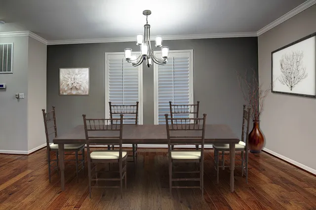 an empty room with wooden floor chandelier and windows