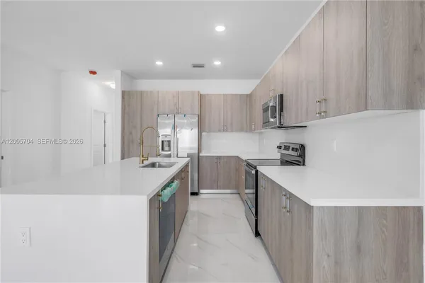 a kitchen with kitchen island sink stove and cabinets