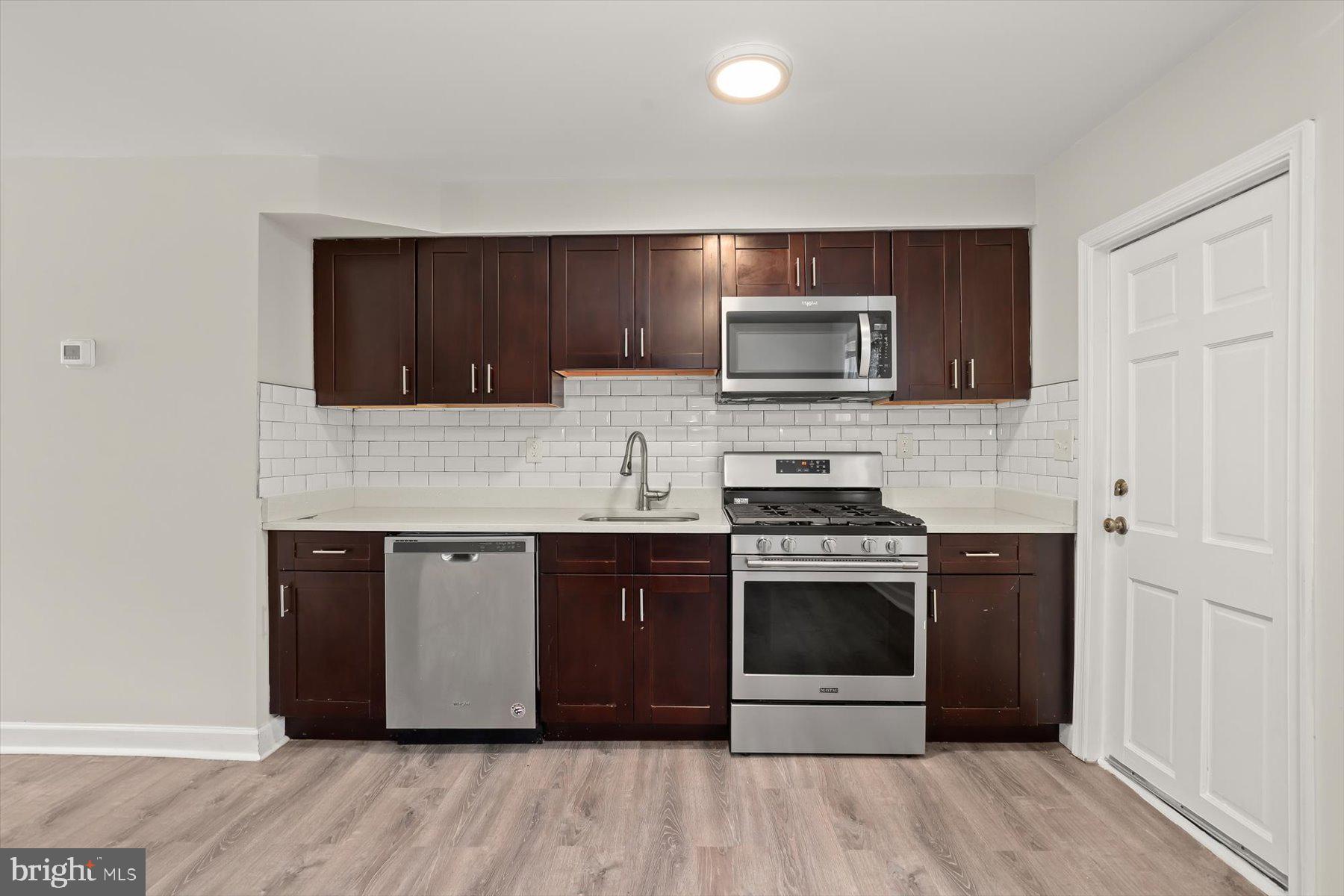1044 Ellicott Driveway Baltimore, MD 21216 - Photo 8 of 26 a kitchen with granite countertop wooden cabinets and stainless steel appliances