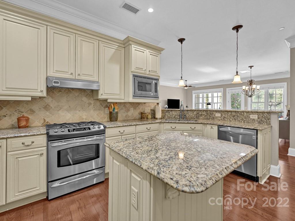 2823 Providence Road, Unit 125 Charlotte, NC 28211 - Photo 15 of 30 a kitchen with stainless steel appliances granite countertop a stove a sink and white cabinets with wooden floor