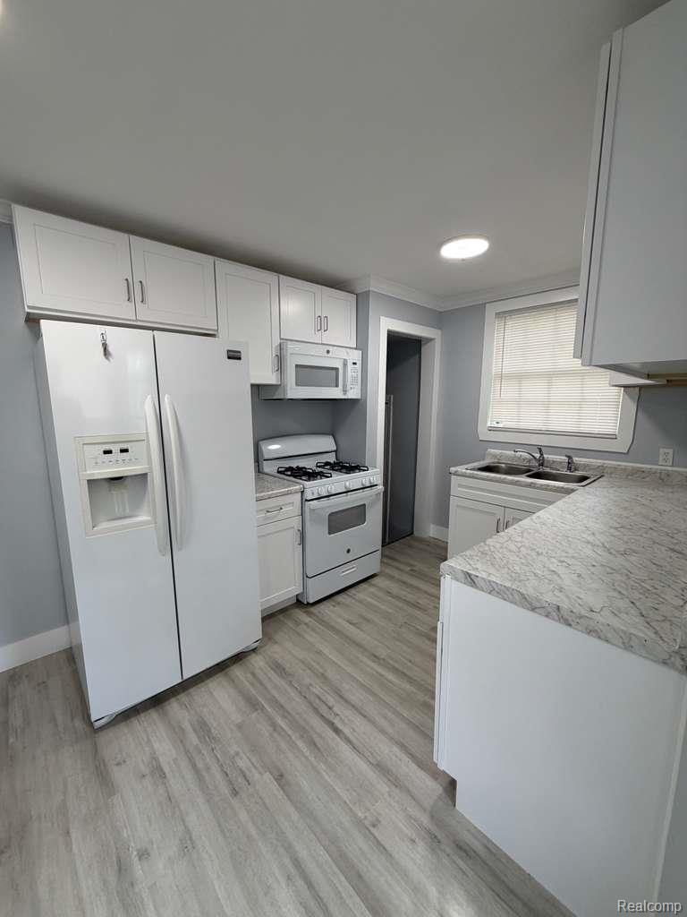 7416 Heyden Detroit, MI 48228 - Photo 9 of 16 Kitchen featuring white appliances, light countertops, white cabinetry, light wood finished floors, and recessed lighting