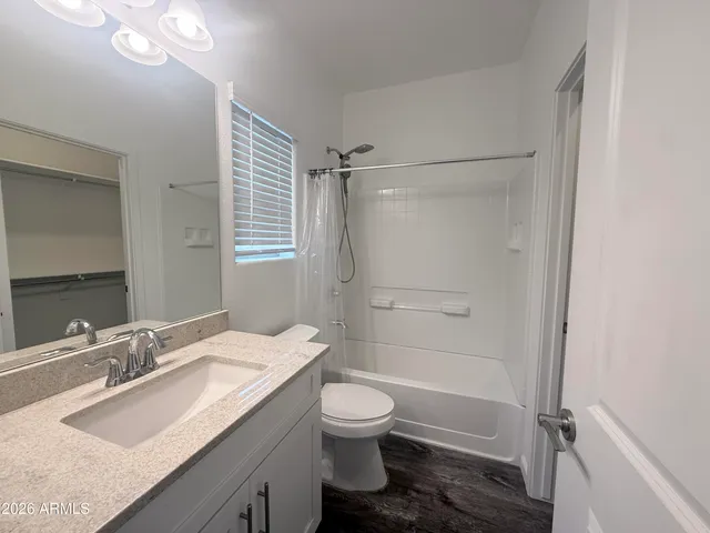 a bathroom with a granite countertop sink toilet a shower and a mirror