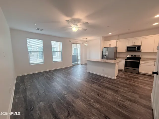 a view of an empty room with kitchen appliances and a window