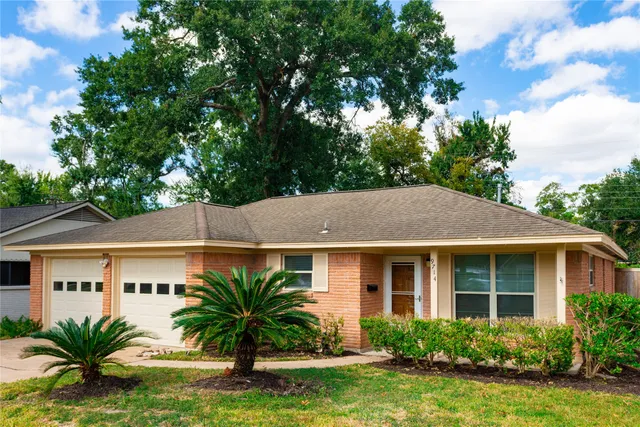 a front view of a house with a garden and yard