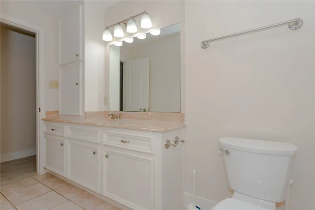 a bathroom with a granite countertop sink a toilet and a mirror