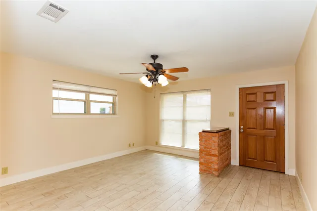 wooden floor in an empty room with a window