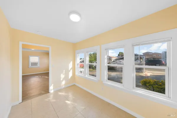 a view of a hallway with wooden floor and a living room
