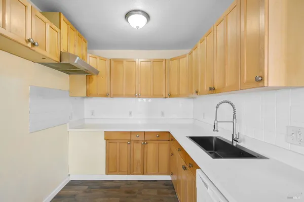 a kitchen with a sink a stove and cabinets