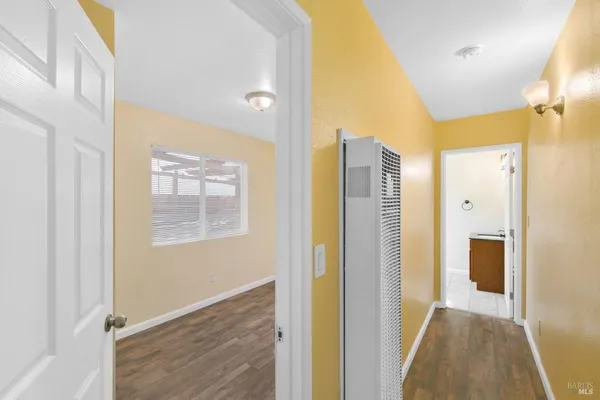 a view of hallway with livingroom and wooden floor
